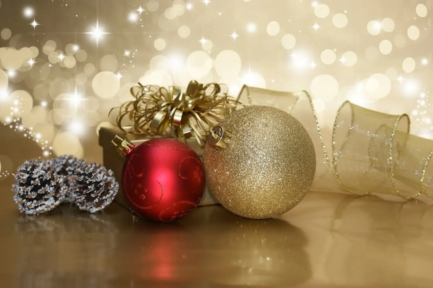 Goldenes Präsent mit zwei Weihnachtskugeln